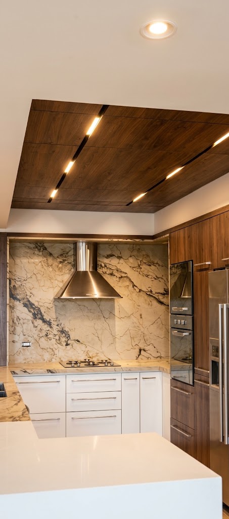 Cocina premium con isla clara, pared de piedra y gabinetes de madera